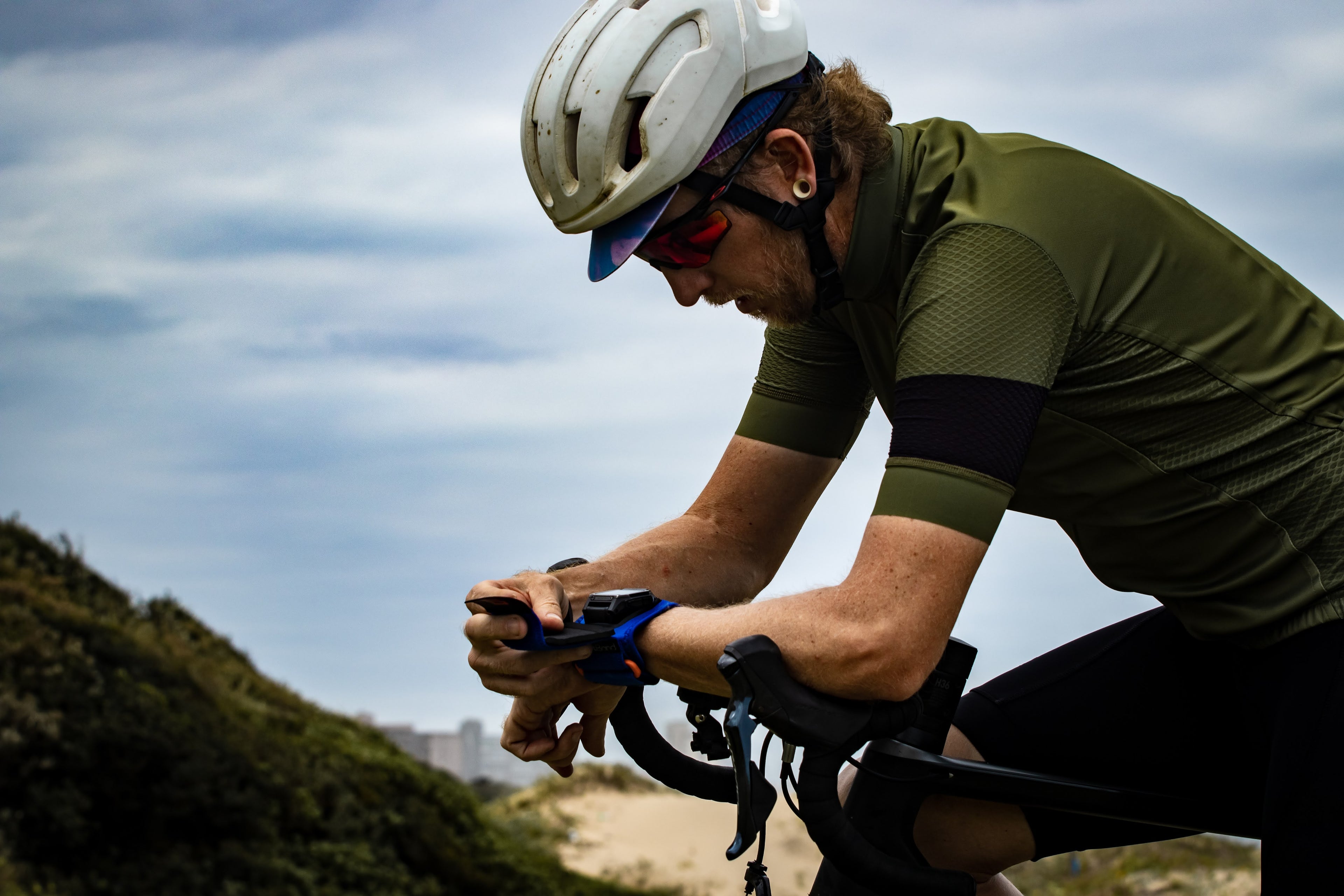 Cyclist using a smartphone on a mountain road
