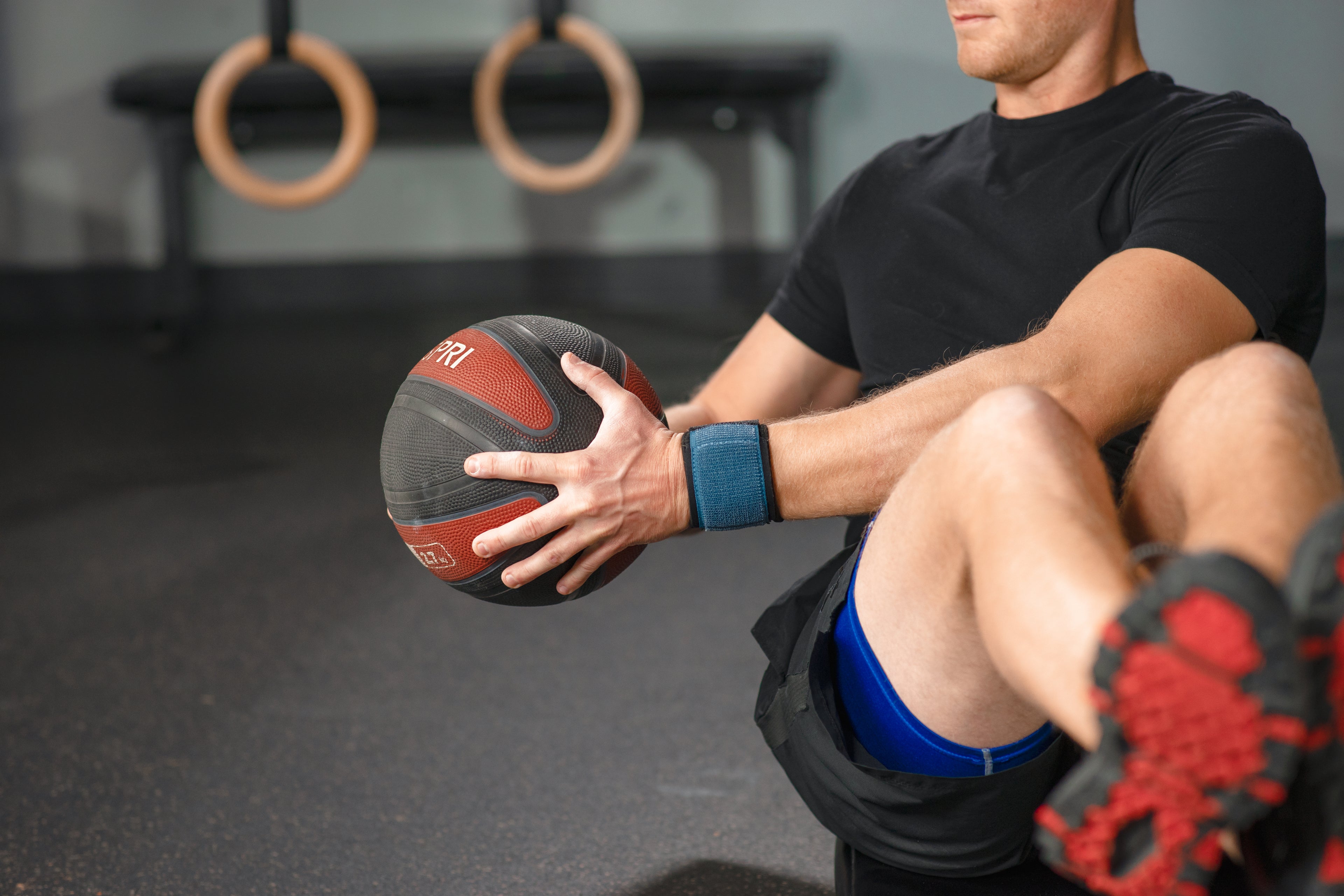 Person holding a medicine ball in a gym setting