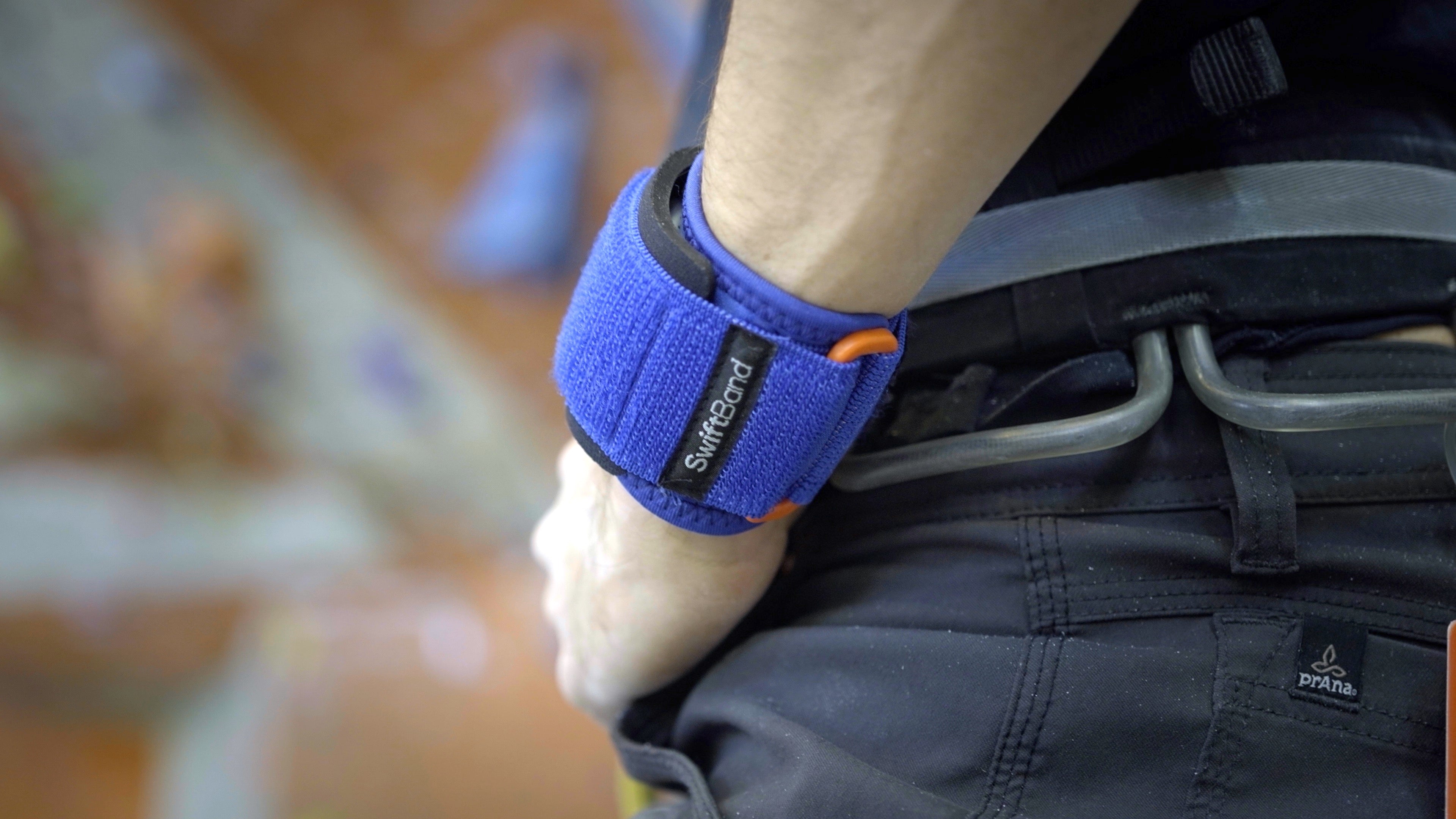Person wearing a blue wrist support with 'Smith' branding on a blurred background
